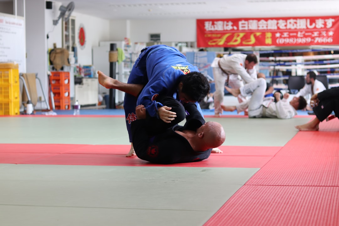 Two BJJ practitioners rolling during no-gi training in rashguards