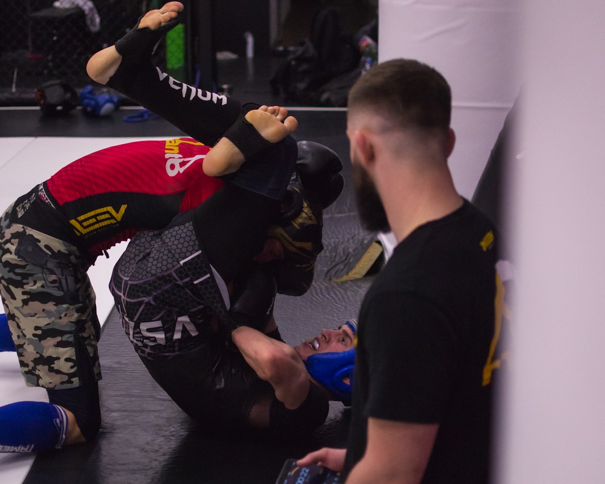 No-gi BJJ grappler training submission grappling techniques in rashguard on the mat