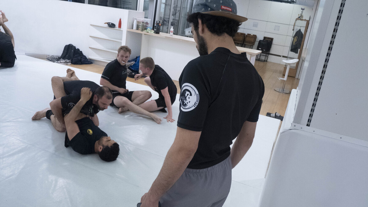 No-gi grappling training session with athletes drilling guard passes and submission techniques