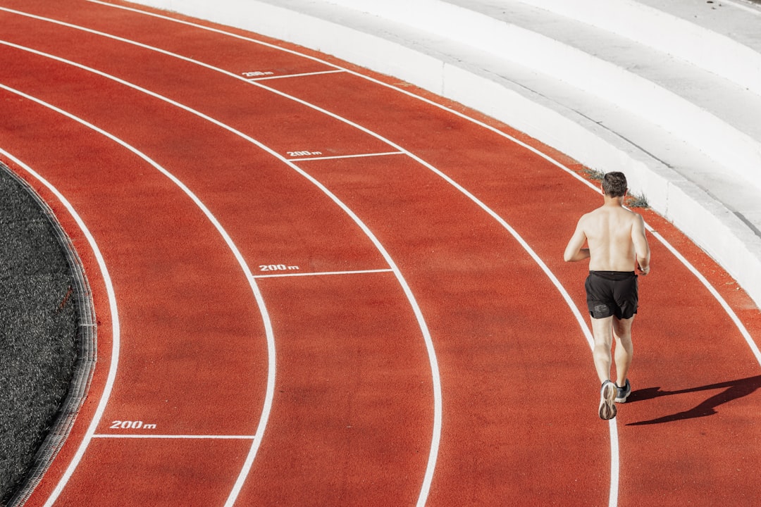 Athlete sprinting on track for interval training and grappling cardio conditioning