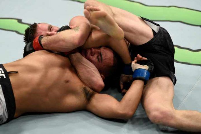 UFC fighter applying anaconda choke variation from front headlock in MMA cage