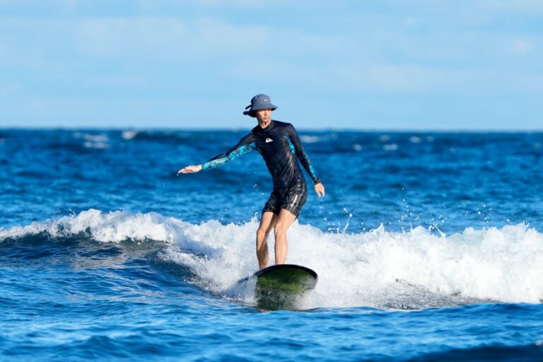 Surfer riding wave under clear blue skies