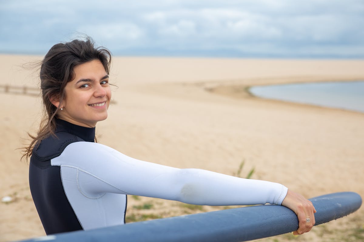 Smiling woman in wetsuit on a beach