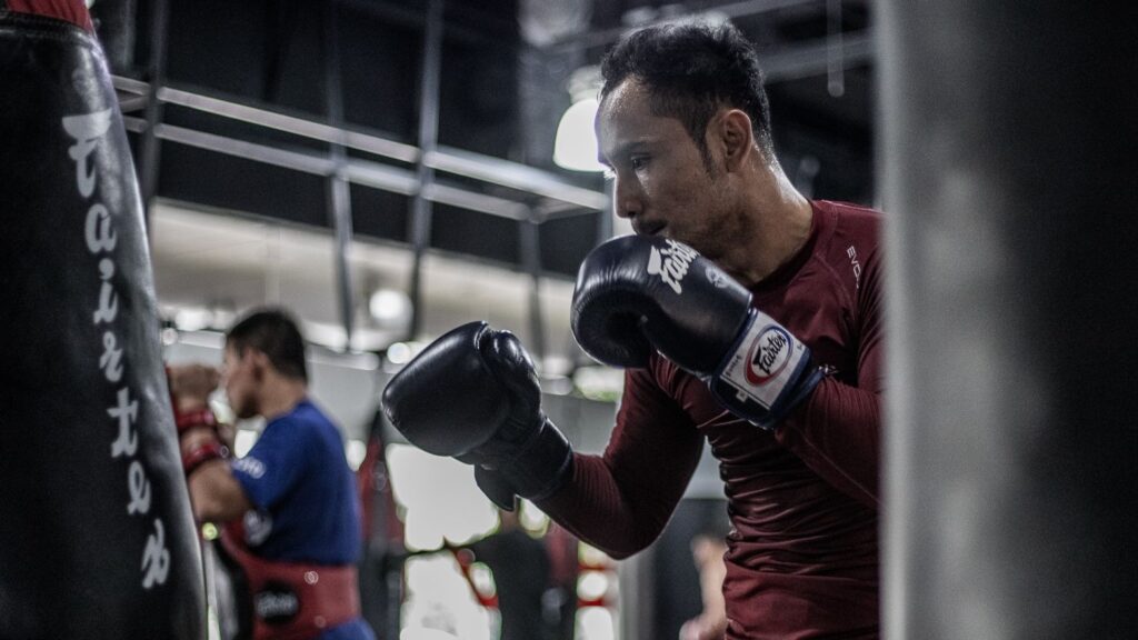 Sam-A training Muay Thai on a heavy bag.