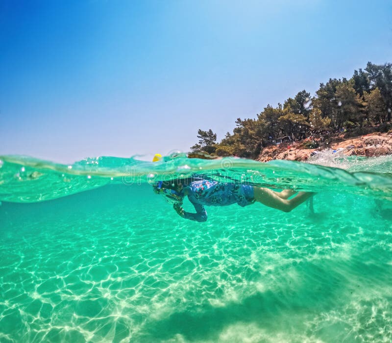 Child Snorkeling Underwater in Crystal Clear Tropical Sea Ocean Water Greece summer vacation. Snorkeling tropical stock image