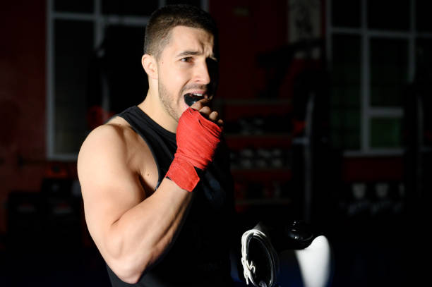 Boxing fighter putting on mouthguard. Boxing fighter putting on mouthguard. High quality photo sports mouth guard stock pictu