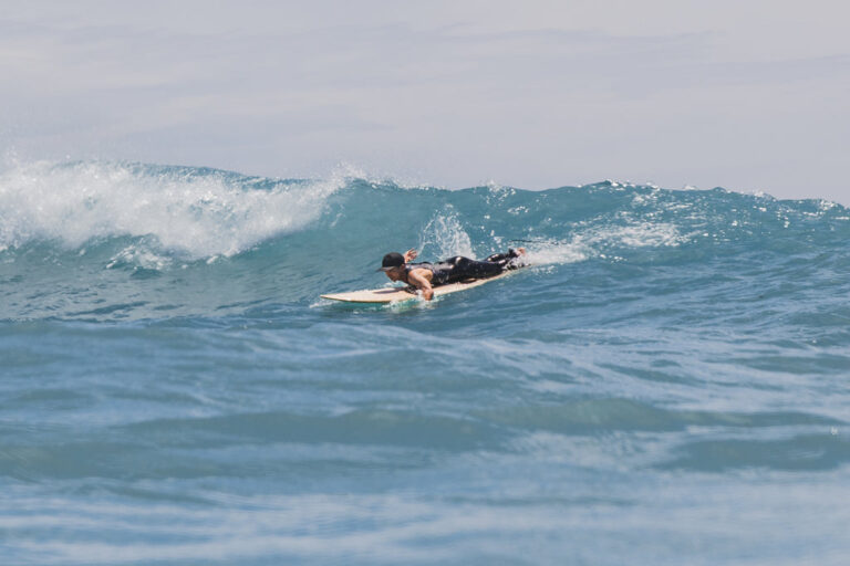 Surfer paddling to catch a wave