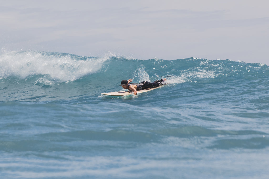 Surfer paddling to catch a wave