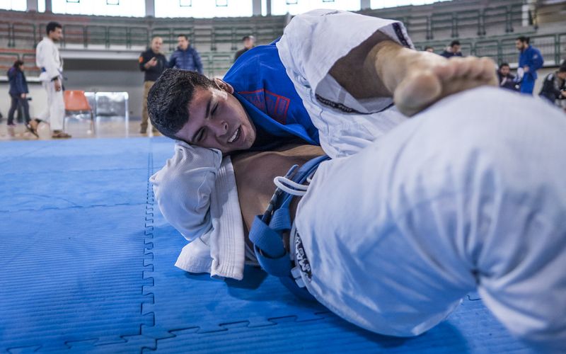 Finishing a no-gi triangle choke at a grappling tournament