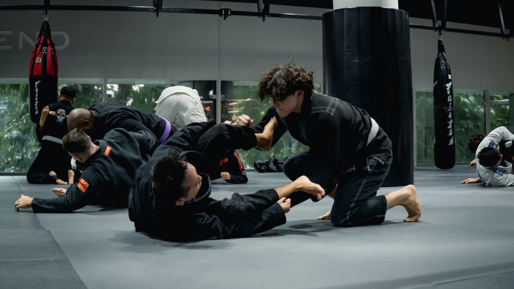 Two students rolling in a BJJ Class at Evolve Far East Square.