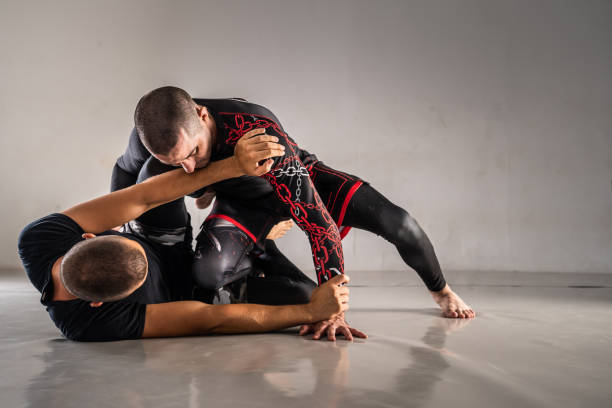 Brazilian jiu jistu bjj no-gi grappling training two male athletes drilling technique or sparring at gym academy guard positi