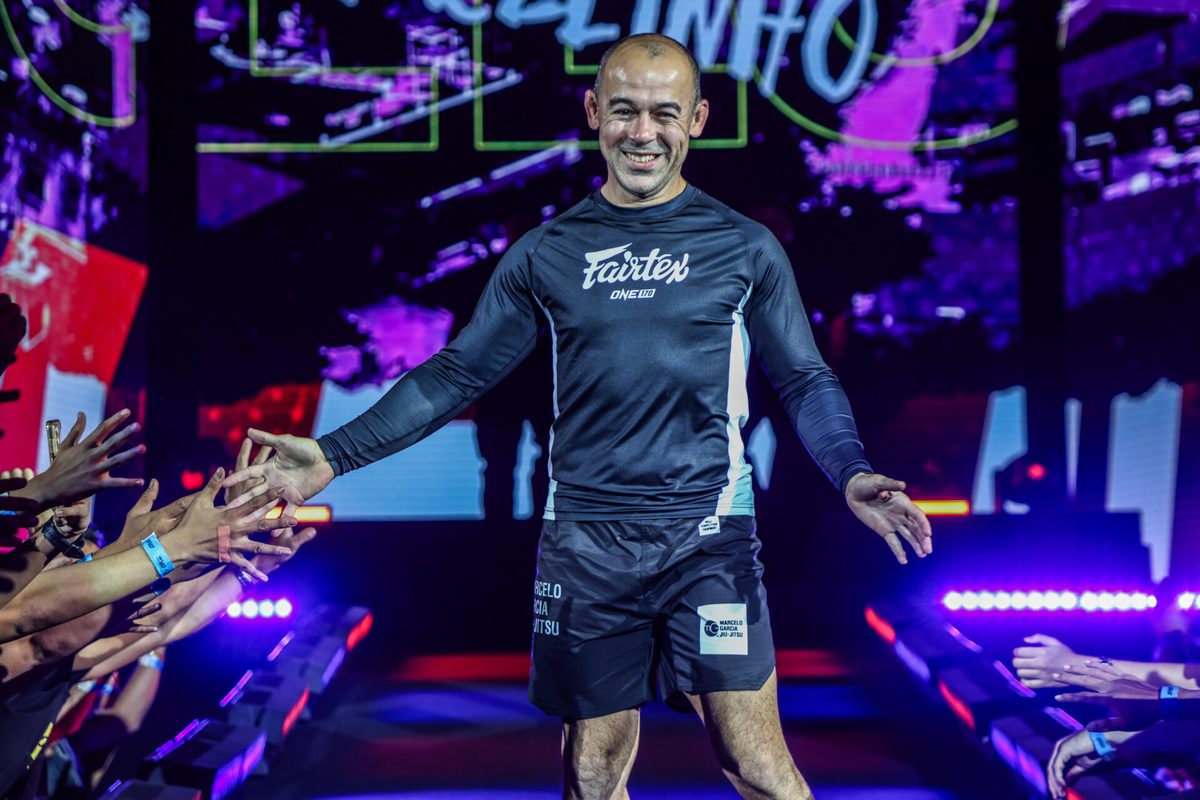Marcelo Garcia competing no-gi in a butterfly guard rashguard