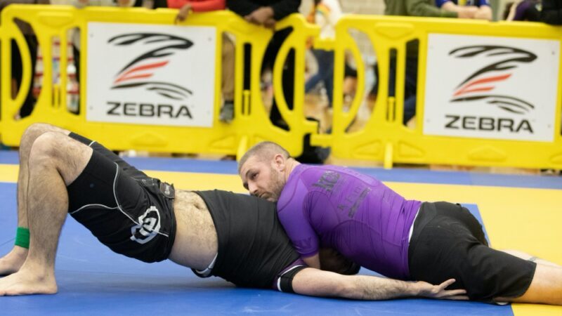 Grappler pinned in no-gi side control before an escape