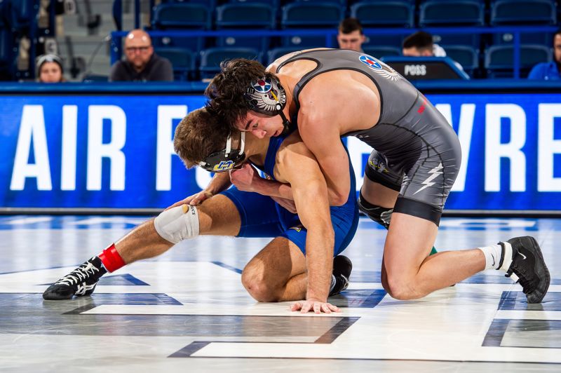 Grappler wearing ear guard headgear during live no-gi wrestling scramble