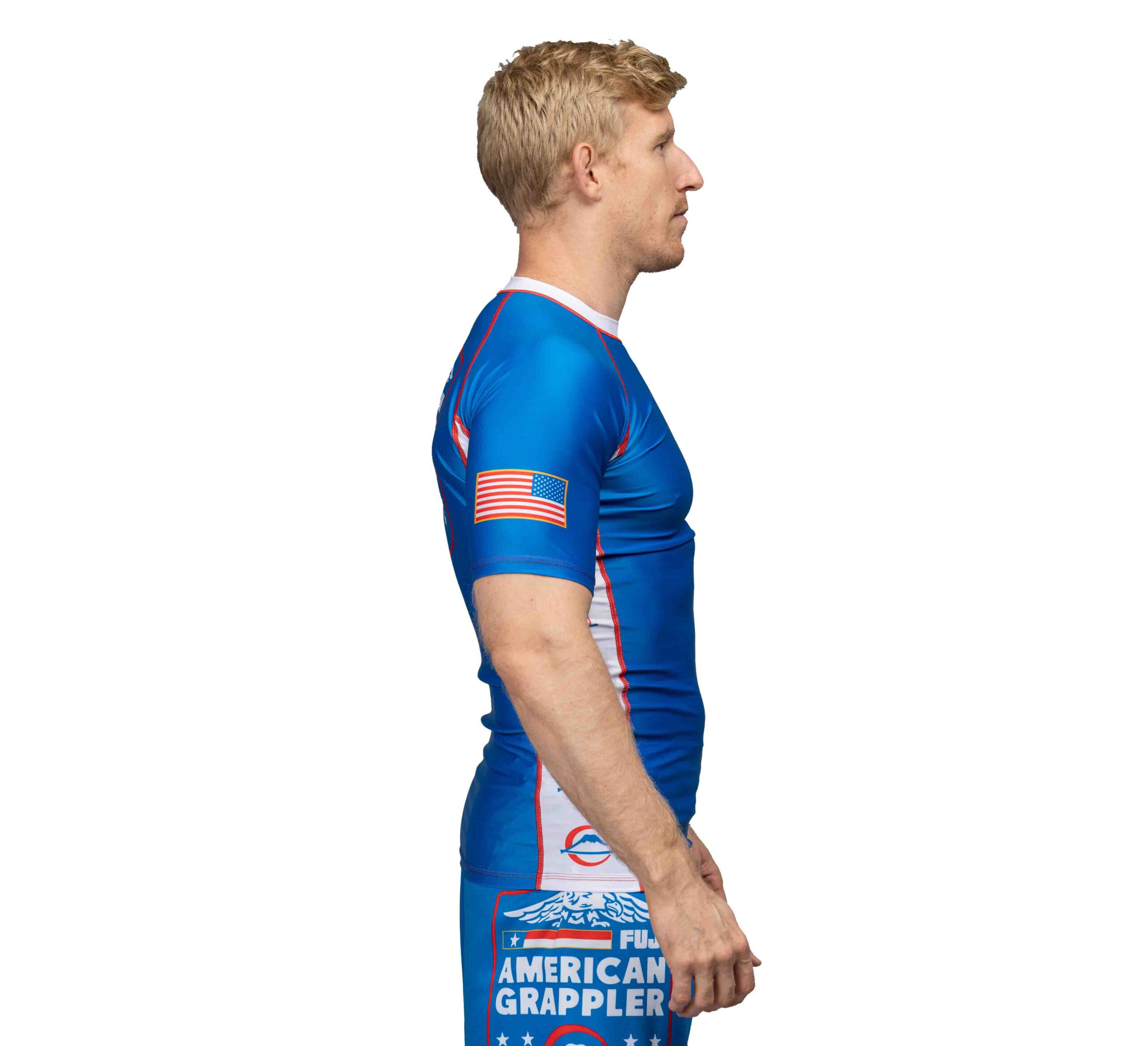 Side profile of a grappler in a fitted short-sleeve rashguard showing a snug compression fit through the torso and arm