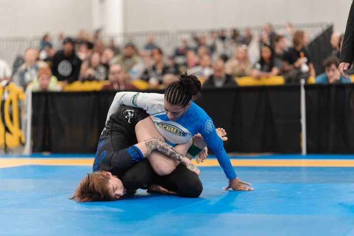 Competitor in a white IBJJF legal rashguard passing guard