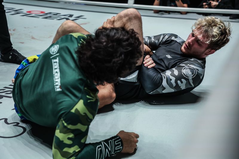 Grappler finishing the knee cut pass into side control in no-gi