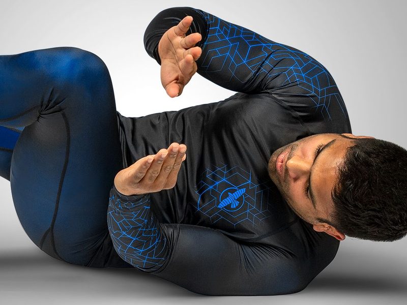 Grappler in a long sleeve rashguard defending guard, sleeves protecting forearm skin