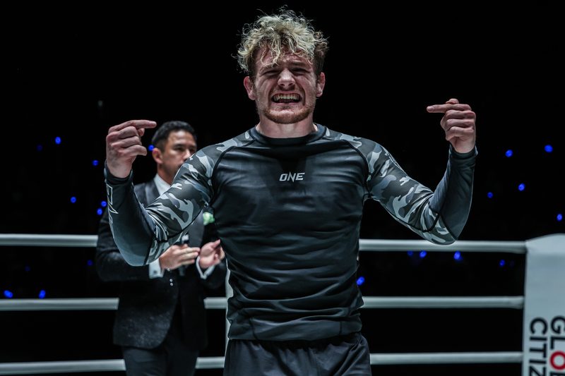 A no-gi grappler celebrates a submission win in competition