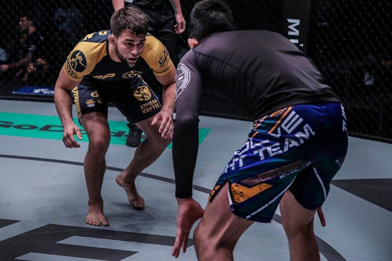No-gi grapplers in a standing exchange before an arm triangle choke setup