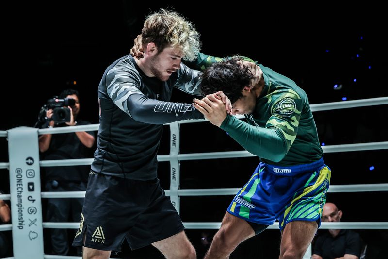 Two no-gi grapplers hand fighting for grips before the knee cut pass