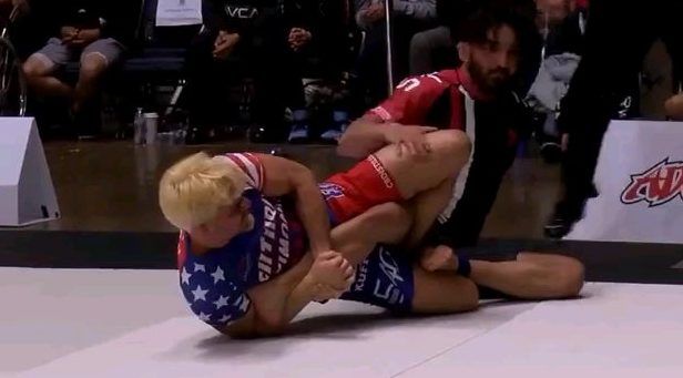 No-gi competitor finishing a leg lock at a submission grappling event