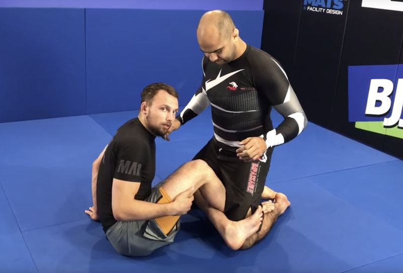 Grappler demonstrating no-gi leg lock control before a kneebar finish