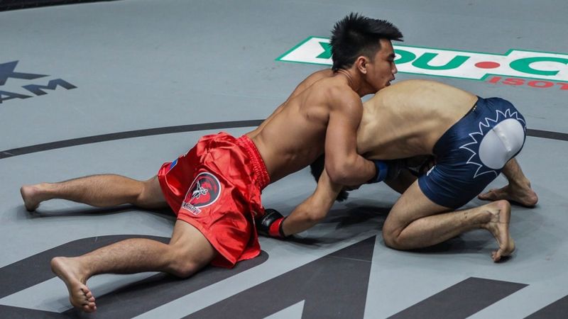 No-gi fighter finishing a takedown into top position