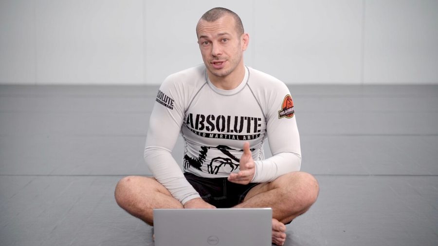 Grappler seated in butterfly guard no-gi with an upright base