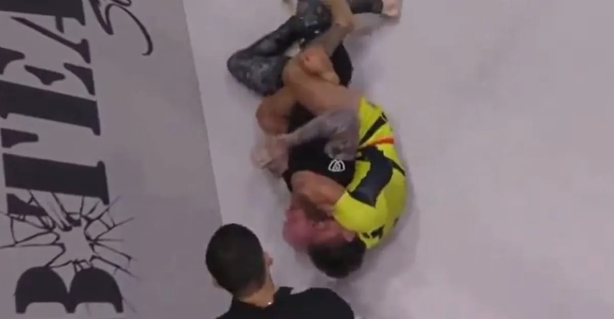 No-gi grappler finishing a submission on the mat from a single leg x guard position
