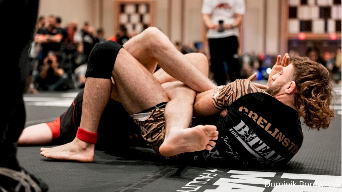 Two no-gi grapplers battling for a leg entanglement and straight ankle lock at a no-gi grappling event