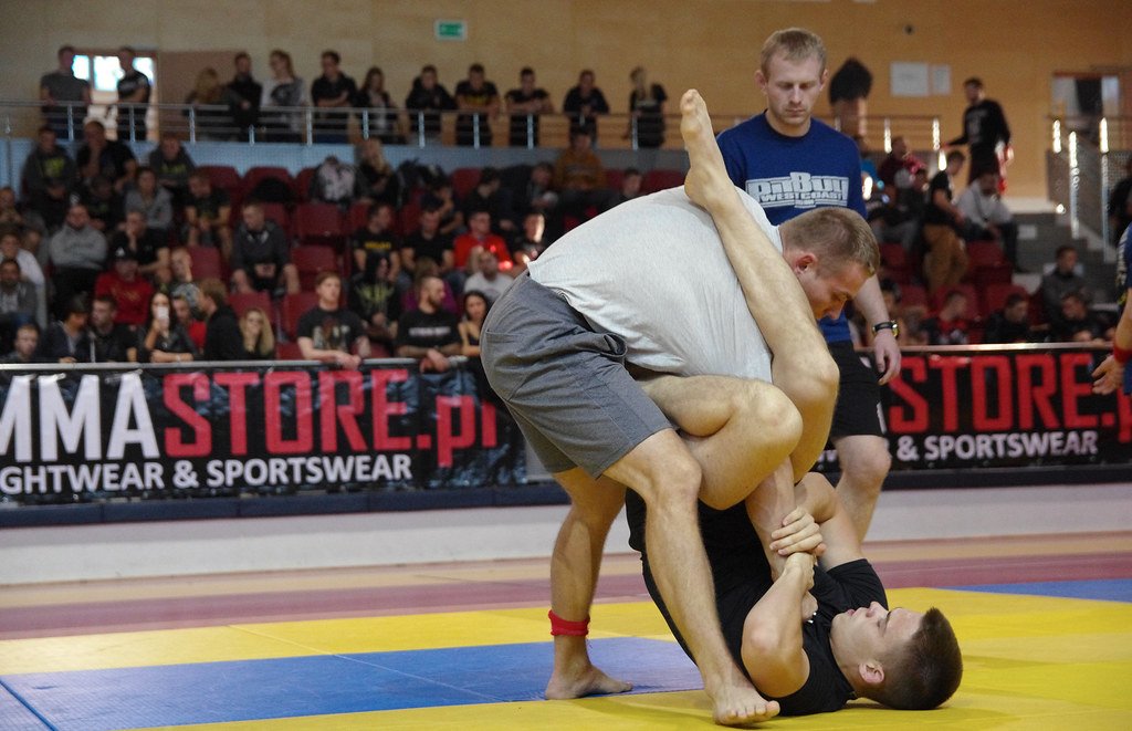 X-guard no-gi sweep battle as a grappler works to off-balance a standing opponent