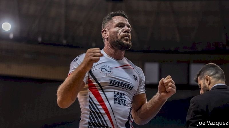 No-gi BJJ grappler celebrates match win at competition in rashguard