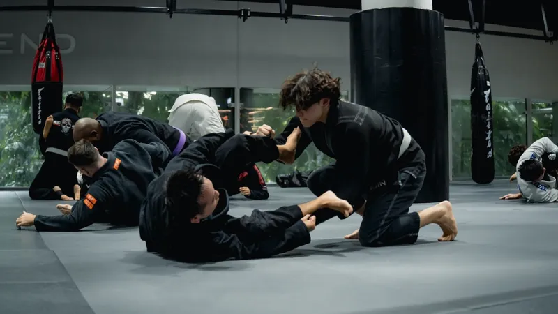 No-gi grapplers drilling entanglement and inversion positions on the mat
