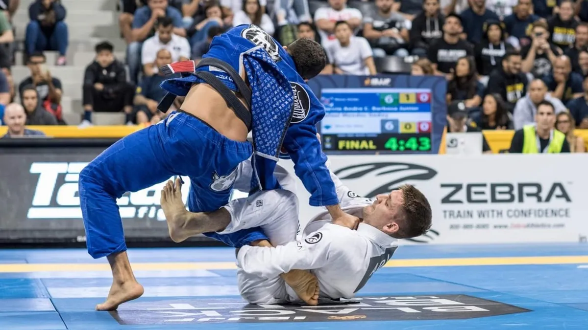Grappler mid-inversion during a no-gi berimbolo entry in live training