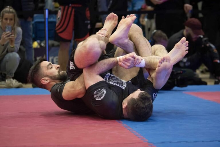 no-gi grappler with taped fingers competing in ADCC heel hook battle