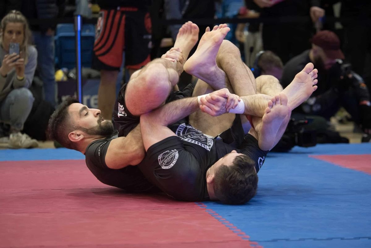 no-gi grappler with taped fingers competing in ADCC heel hook battle