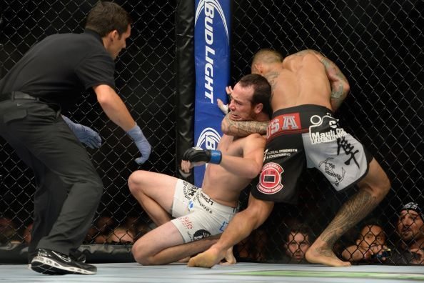 No-gi reverse bulldog choke finished against the cage in an MMA bout
