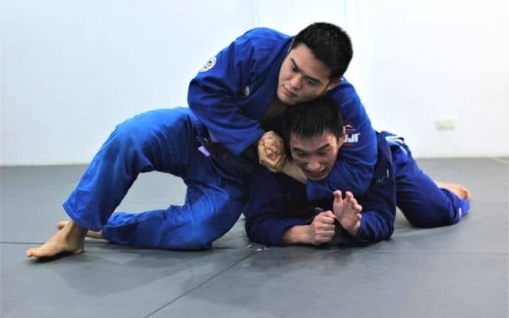 No-gi grapplers demonstrating the bulldog choke from turtle position