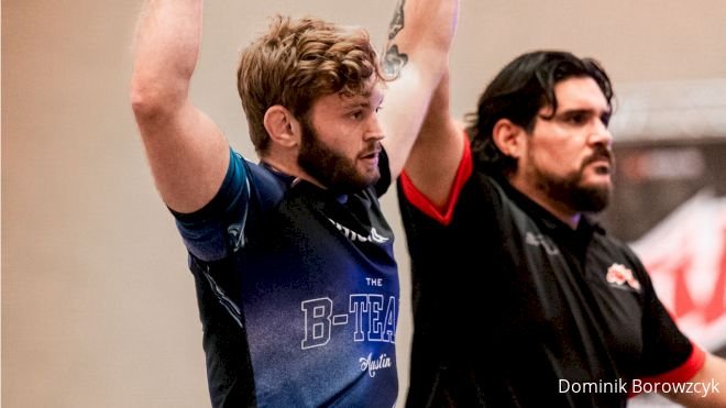 Two grapplers celebrating after a no-gi match, rashguards visibly worn through competition