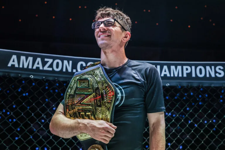 No-gi submission grappling world champions posing with title belts after a match