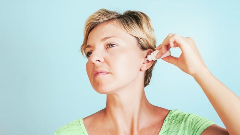 woman putting drops in ears