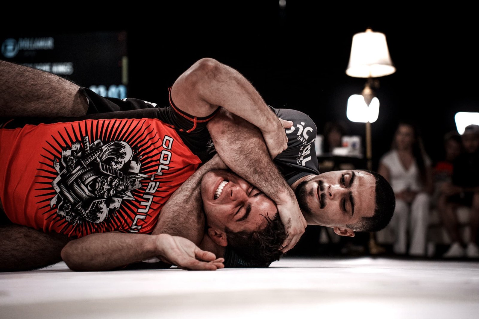 Two PGF no-gi grapplers mid-match wearing sponsor-branded competition rashguards