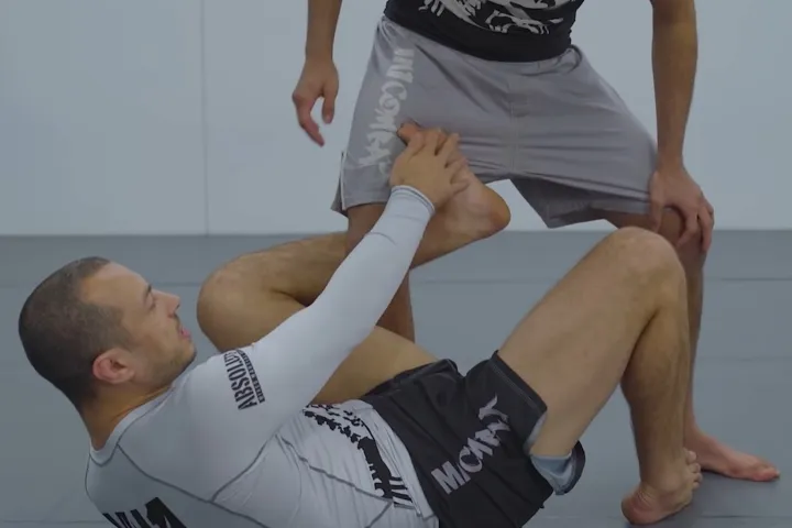 No-gi grappler maintaining shoulder weight distribution during an inverted guard position