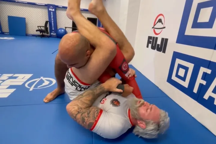 No-gi grappler finishing an armbar attack from an open guard sequence