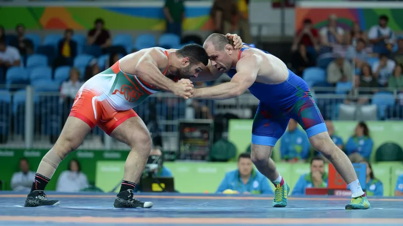 Olympic wrestlers hand fighting from a collar tie before an ankle pick attempt