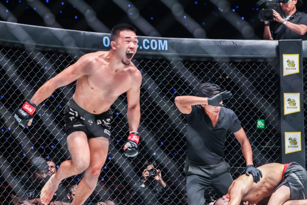 Christian Lee celebrating a finish in the ONE Championship cage