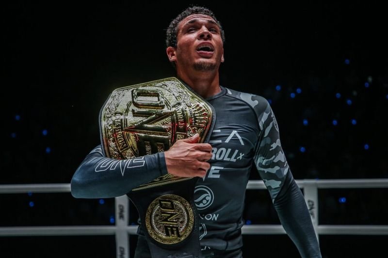 No-gi grappling champion holding a ONE Championship title belt
