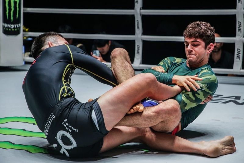 Two no-gi grapplers in a leg entanglement on the mat, the entry point competitors use to set up a crab ride back take