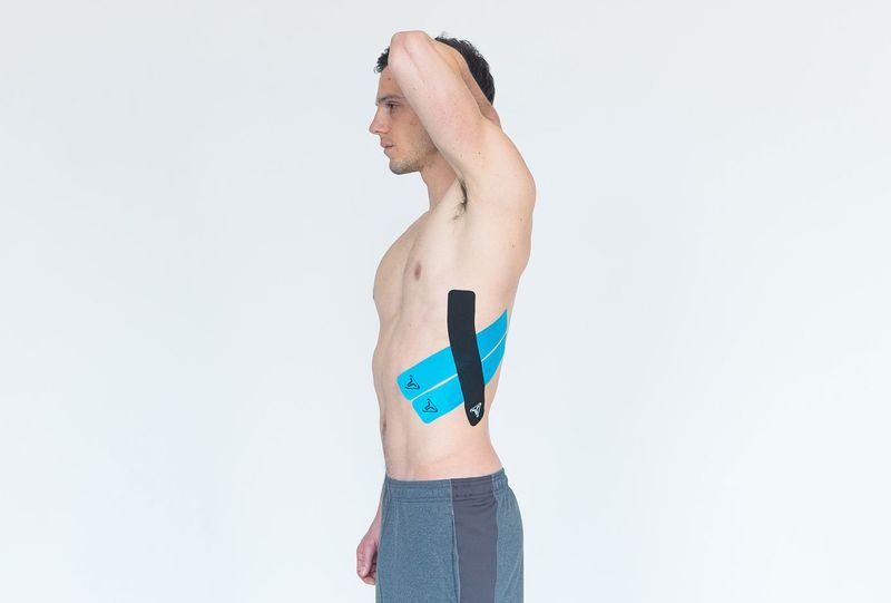 Finished kinesiology tape application over a grappler's ribs for compression and support